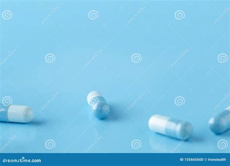 medication capsules spilled on blue pastel coloured background medication and prescription