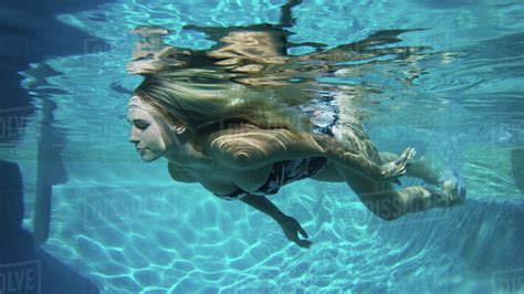 Underwater View Of Woman In Bikini Swimming In Pool Stock Photo