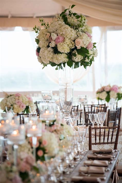 A Beautiful Tall Centerpiece Using Hydrangea And Roses