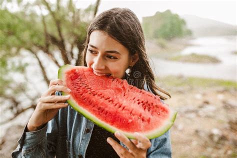 Young Woman Eating Watermelon On A Rainy Summer Day Stock Photo Image