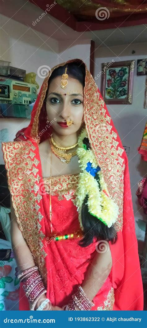 a beautiful newly married girl is sitting in sari and ornamants editorial photography image