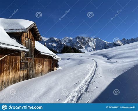 Idyllic Swiss Alpine Mountain Huts Dressed In Winter Clothes And In A