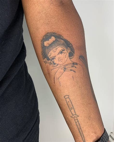 A Woman With A Tattoo On Her Arm Holding A Syringon In Her Hand