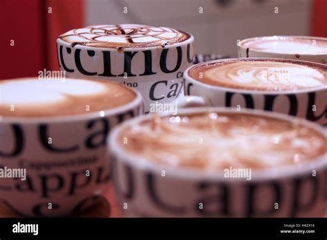 Four Cups Of Cappuccino With Decorated Foam And Bokeh Stock Photo Alamy