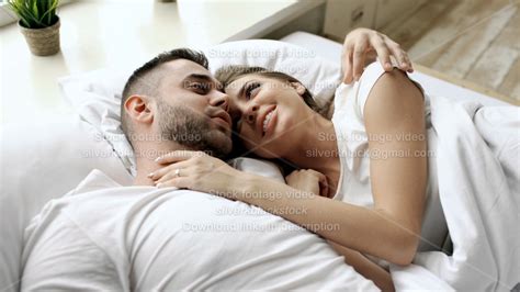 Closeup Of Young Beautiful And Loving Couple Talk And Hug Into Bed