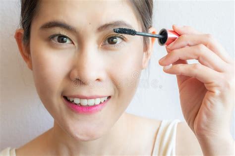 Close Up Of Young Asian Woman Applying Black Mascara On Her Eyelashes
