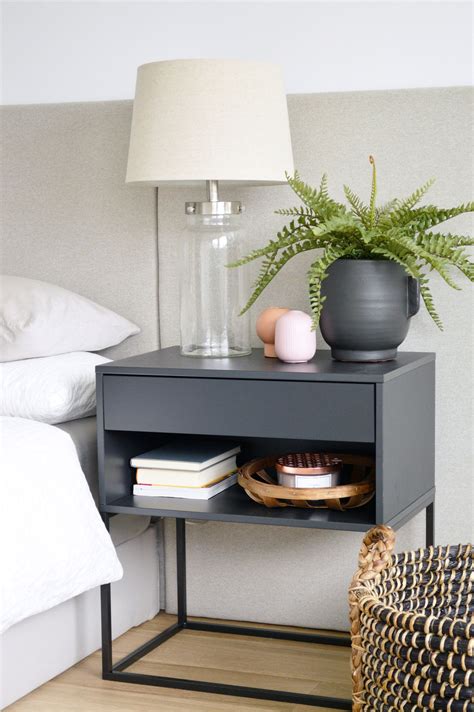 a nightstand with a plant and some books on it