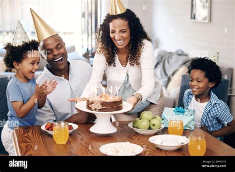 afroamerikanische familie feiert geburtstag zu hause mom macht geburtstagskuchen mit kerzen auf
