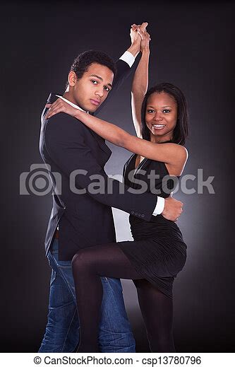 Portrait Of African Couple Dancing Over Grey Background