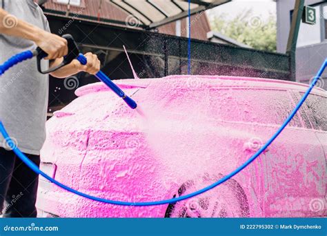 car wash with soap car cleaning with high pressure water a person washes the car washes off