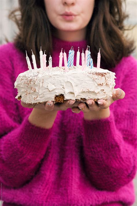 Female Blowing On Her Birthday Cake In Hands Del Colaborador De