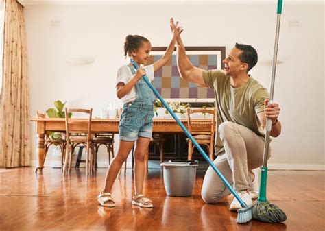 Adorable Little Girl Helping Her Father Sweep And Mop Wooden Floors For