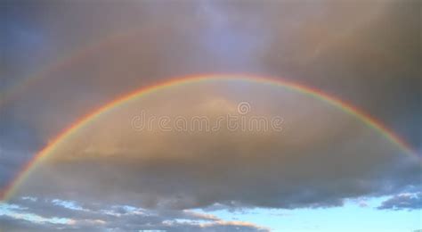Full Double Rainbow In The Sky Against The Background Of Clouds Stock