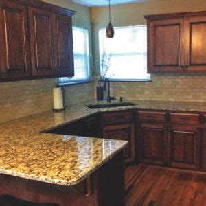 White painted cabinets with black tile backsplash. The project included new countertops, refinished cabinets ...