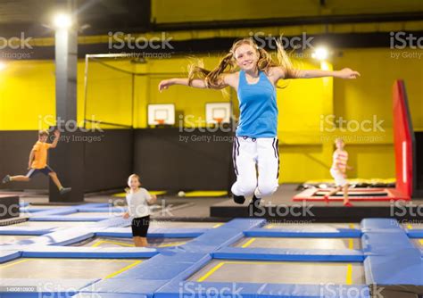 Teenage Girl Bouncing On Trampoline In Indoor Amusement Park Stock