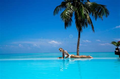 Elegant Tanned Woman In White Swimsuit In Pool On Tropical Maldives