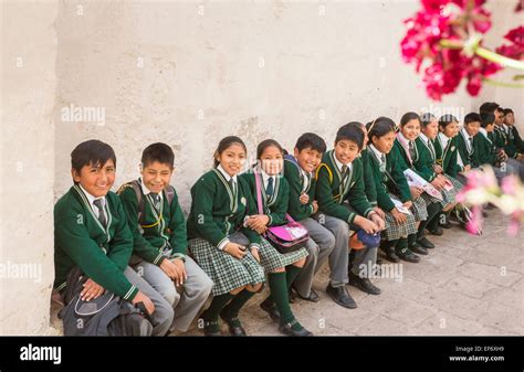 Local Happy Peruvian Schoolchildren In School Uniform Sitting On A