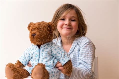 Disheveled Little Girl Holding Her Pyjama Clad Teddy Bear Stock Image