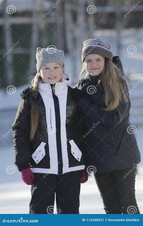 Portrait Of Two Teenage Girls Wearing Winter Clothes In Winter Outside