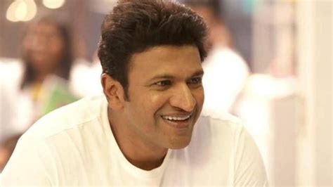 Puneeth Rajkumar Is Wearing White T Shirt Sitting In Blur Background Hd