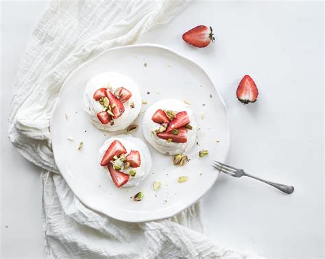 Desert pavlova has an interesting history of origin. Small strawberry and pistachio pavlova meringue cakes with ...