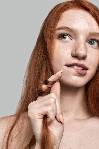 Close Up Portrait Of Young And Cute Redhead Woman Playing With Her Hair