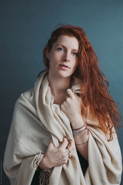 Portrait Of Young Red Head Woman With Blanket On Solid Background By
