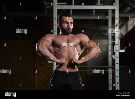 Young Man Standing Strong In The Gym And Flexing Front Lat Spread Pose