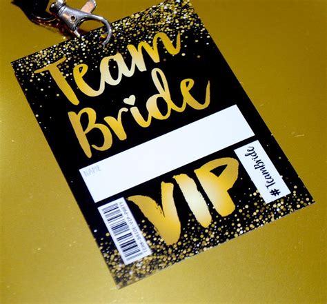 A Black And Yellow Tag With The Words Team Bride Up Written In Gold On It
