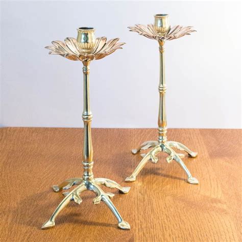 Two Metal Candlesticks Sitting On Top Of A Wooden Table