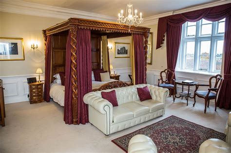 A young woman in a red dress on a black leather sofa. Deep red curtains surround the 8ft four poster bed | Red ...