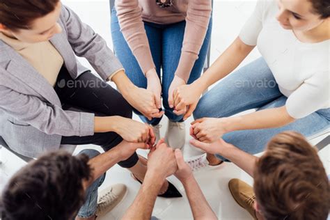 Top View Of People Holding Hands During Group Therapy Session Stock