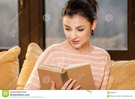 woman sitting on her couch at home and reading a book stock image image of lounge sofa 69603741