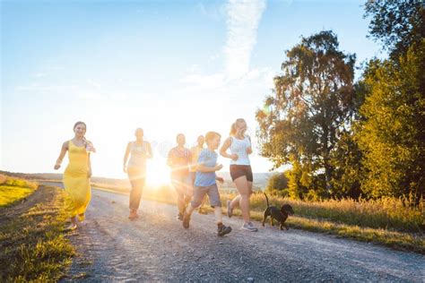 Familia Juguetona Que Corre Y Que Juega En Una Trayectoria En Paisaje