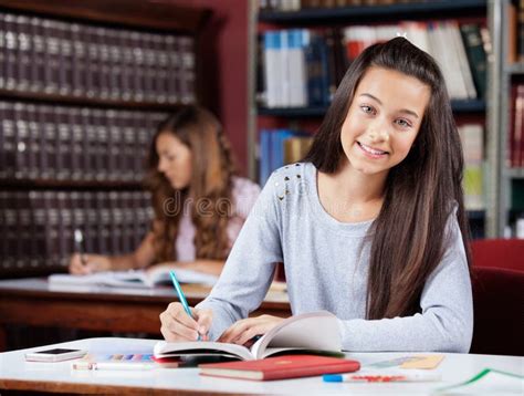 Teenage Schoolgirl Writing In Book At Table Stock Photo Image Of