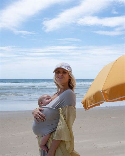 a gorgeous blonde beach bunny mum wears her little babe with they help of a chekoh stretchy wrap