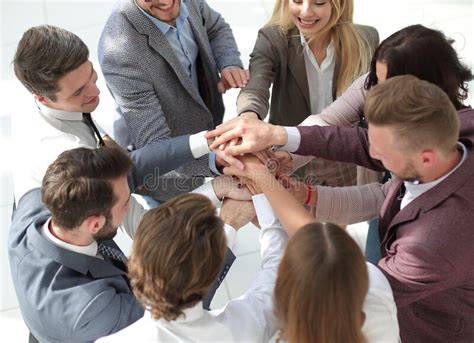Group Of Young Business People Putting Their Hands Together Stock