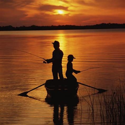 Silhouette Of Father And Son Fishing At Sunset Photographic Print By