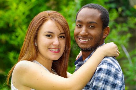 Interracial Charming Couple Wearing Casual Clothes Embracing And Posing