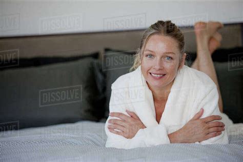 Portrait Of Mature Woman Lying On Bed Stock Photo Dissolve