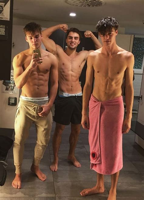 Three Men Standing Next To Each Other In The Bathroom With No Shirts On