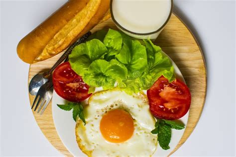 Breakfast With Bread Fried Eggs Milk And Vegetables And Fried Tomato