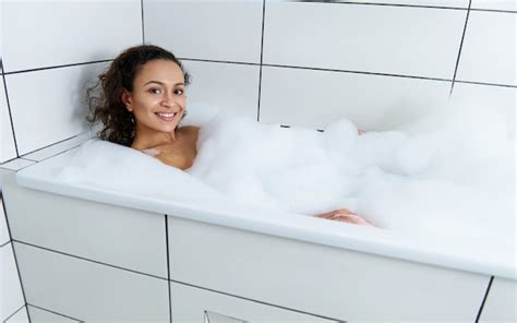 Happy Beautiful Woman Relaxing In A Bubble Bath Tub At Home Relaxing At