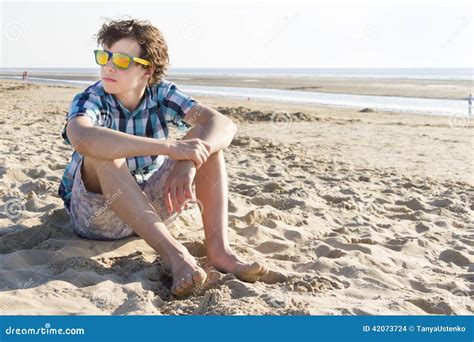 Adolescente Que Senta Se Na Praia Foto De Stock Imagem De Camisa