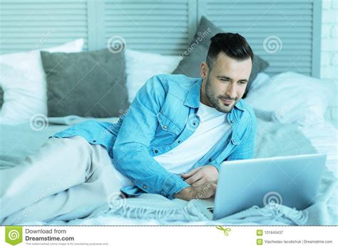Relaxed Millennial Guy Lying In Bed With Laptop Stock Image Image Of