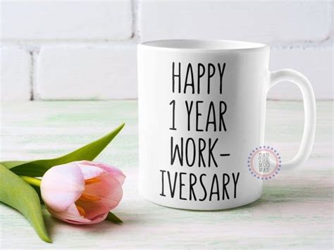 A Coffee Mug With The Words Happy 1 Year Work Iversary On It Next To
