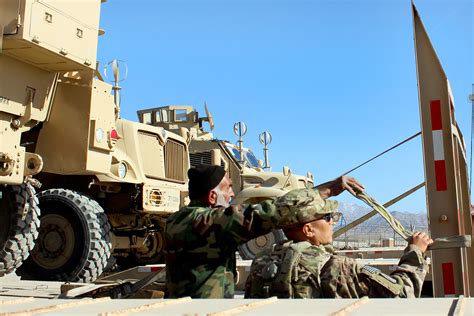 A Us Soldier Helps An Afghan Contractor Tie Down And Secure An Mine