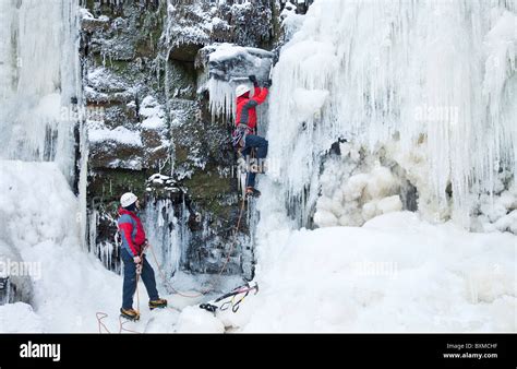 Two Men Engaged On An Ice Climb On A Frozen Waterfall Lynn Falls