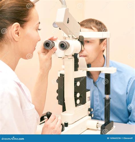 Ophthalmologist Doctor In Exam Optician Laboratory With Male Patient