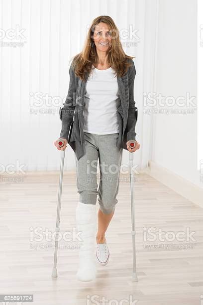 Woman Holding Crutches While Walking Stock Photo Download Image Now